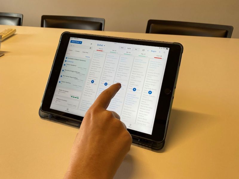 User testing the visit planning interface on an iPad, demonstrating the weekly calendar view during a usability testing session